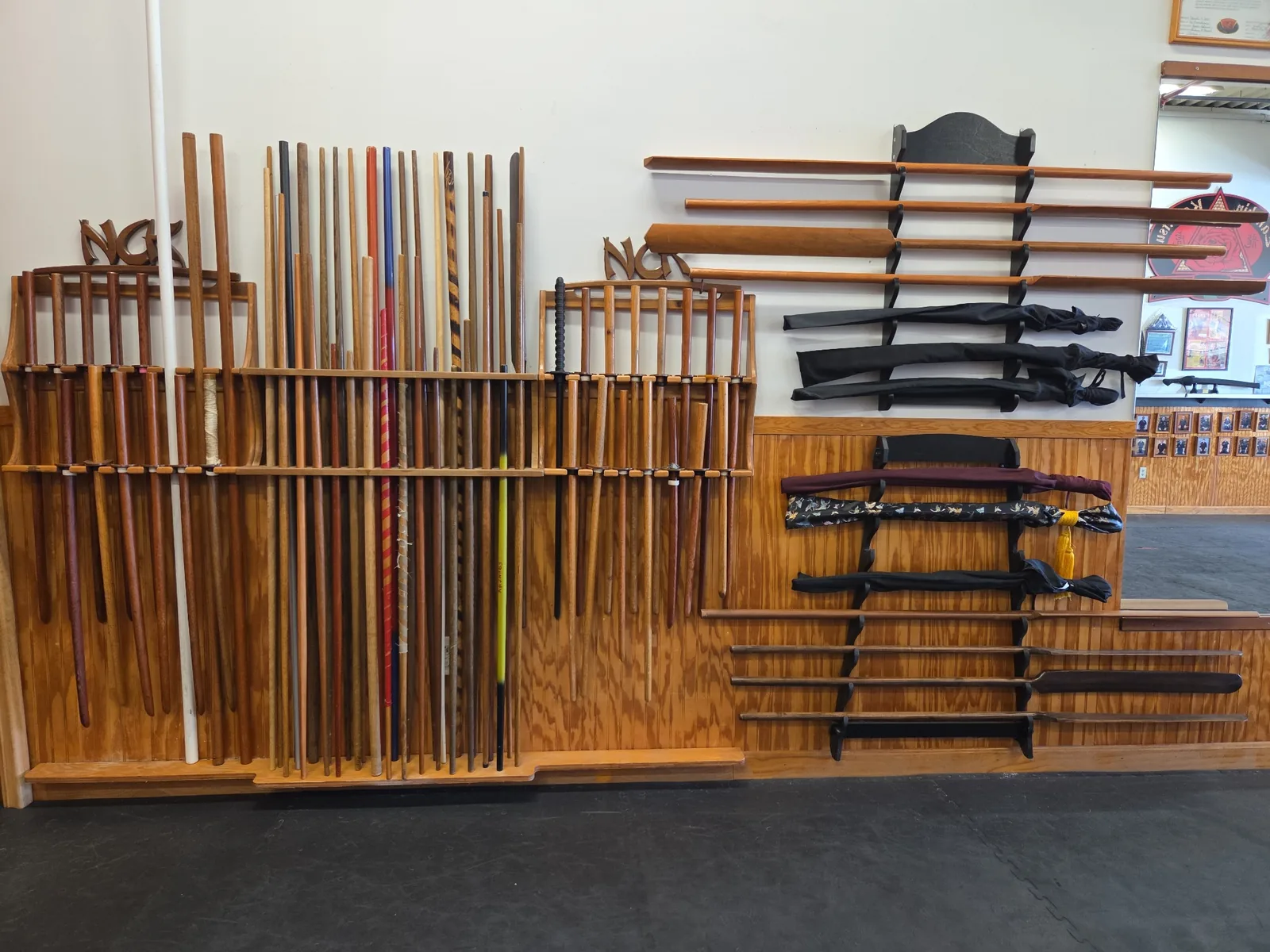 Large wall rack containing a range of traditional martial arts weapons