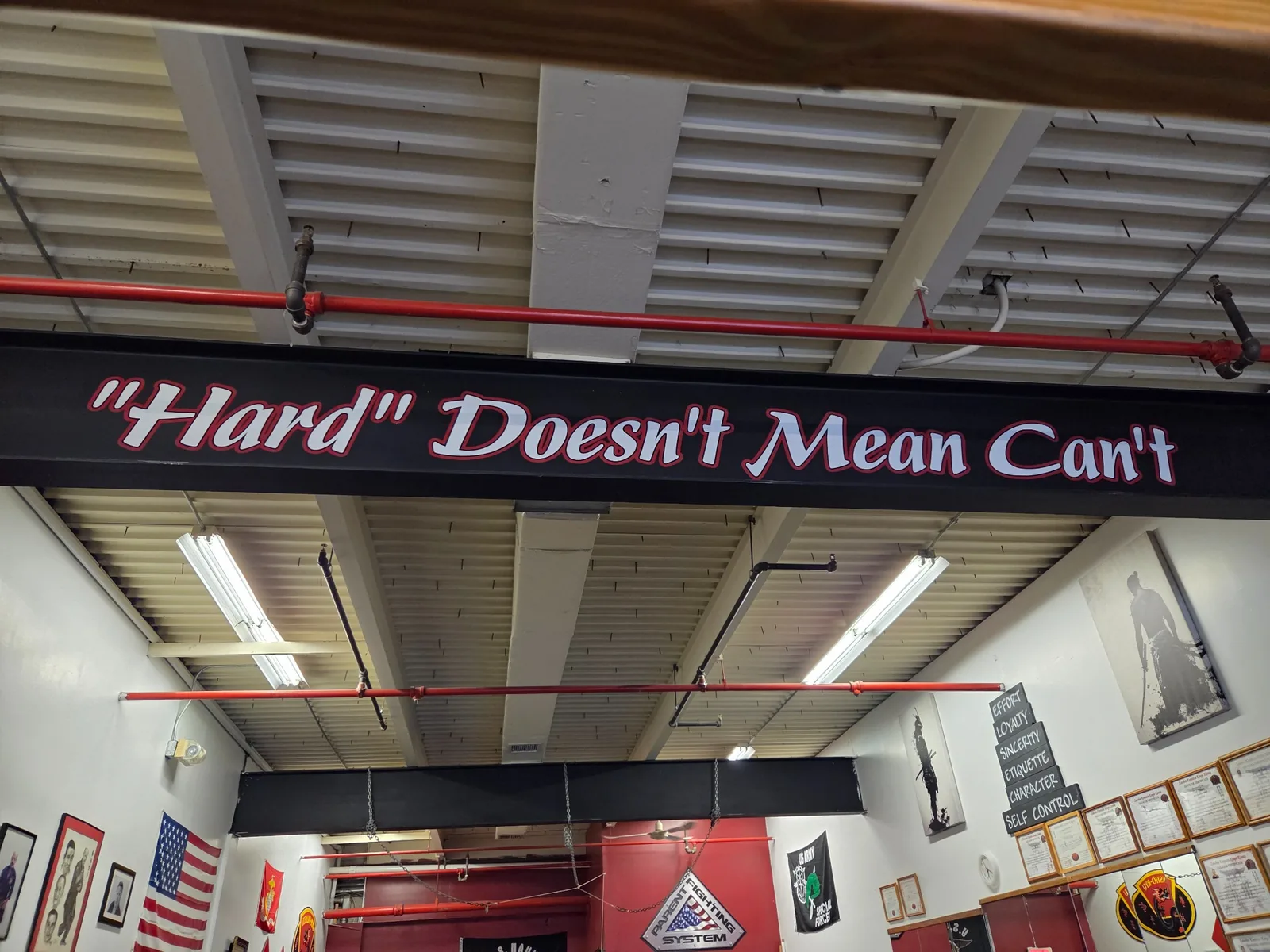 Wide view of the Zanshin dojo beneath the phrase Hard Doesn't Mean Can't