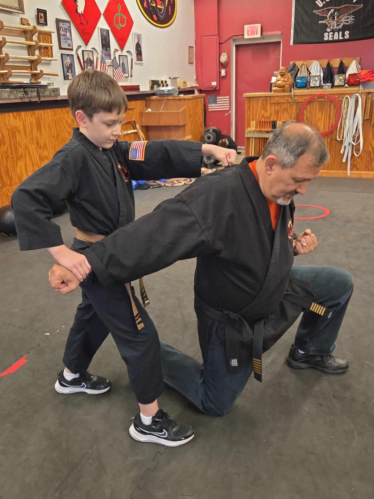 Zanshin instructor working one-on-one with a youth brown belt on a self-defense technique