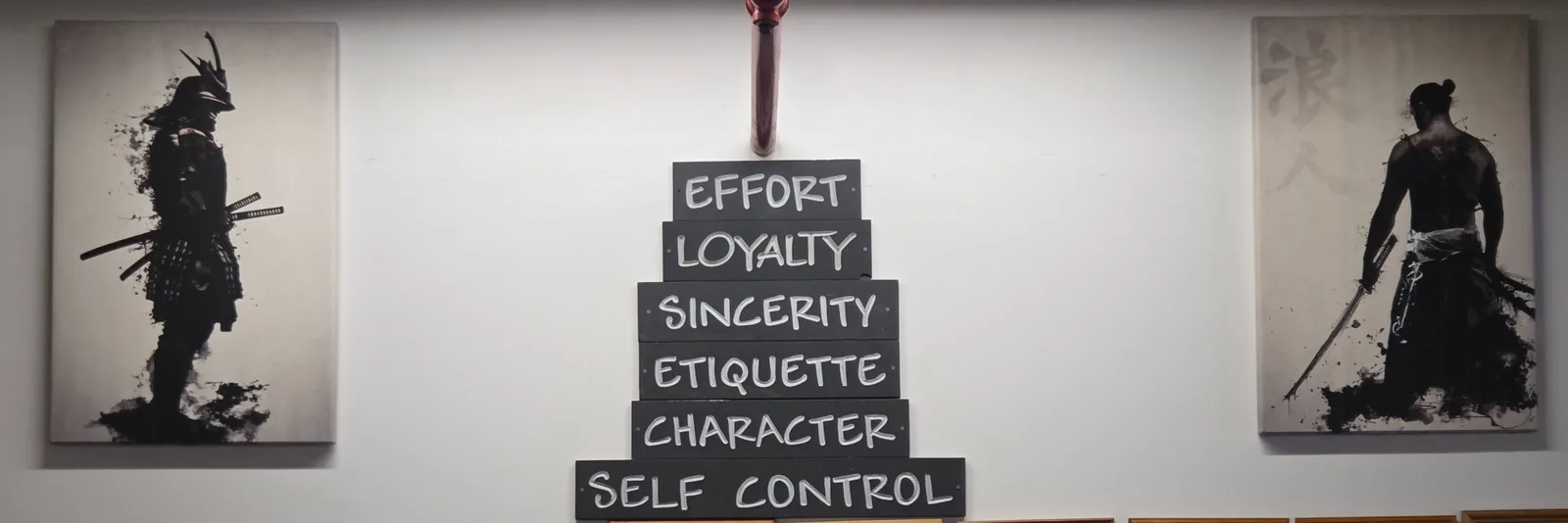 Zanshin's six codes of conduct displayed in the dojo: effort, loyalty, sincerity, etiquette, character, and self control